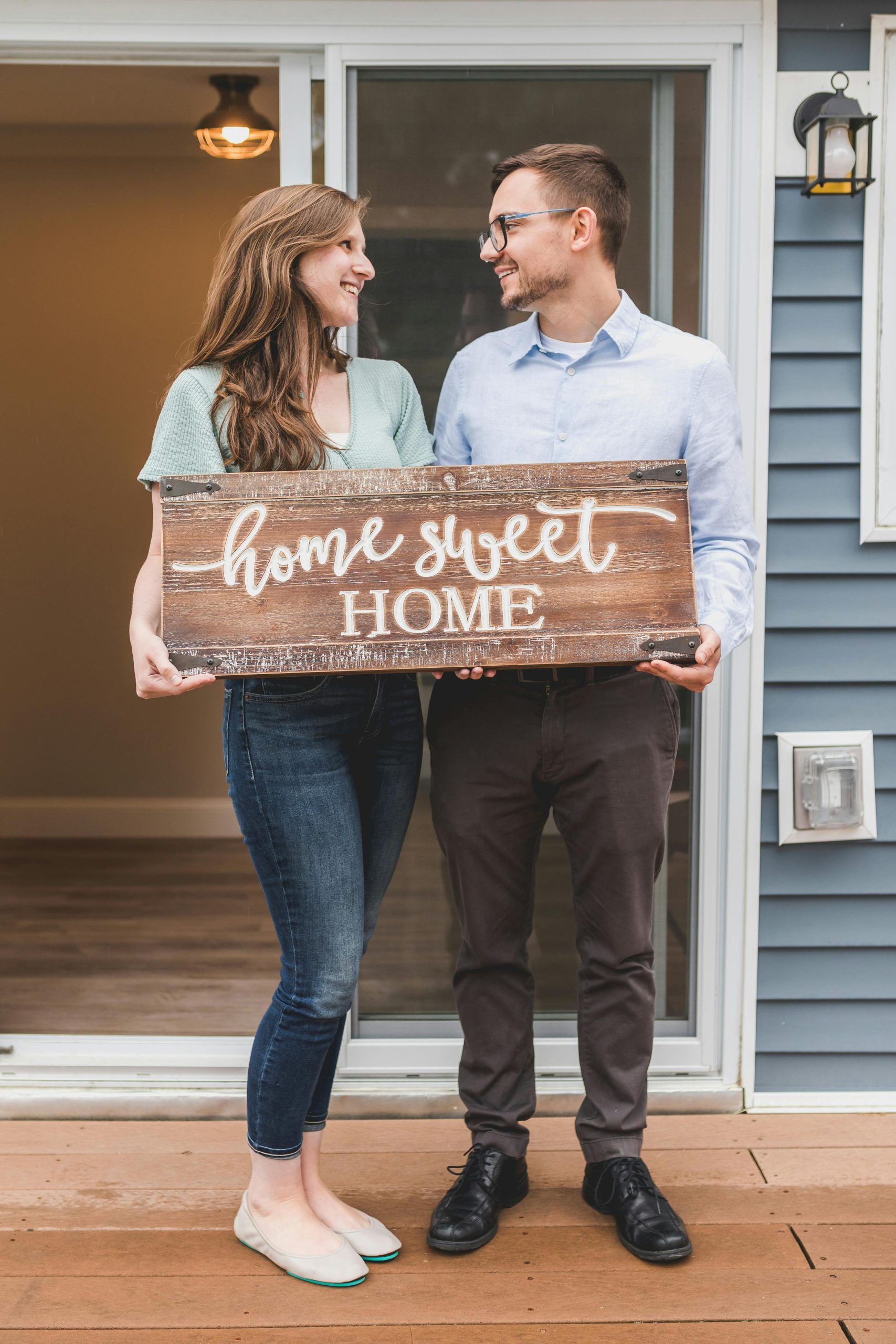 Home buyers smiling on the porch after closing